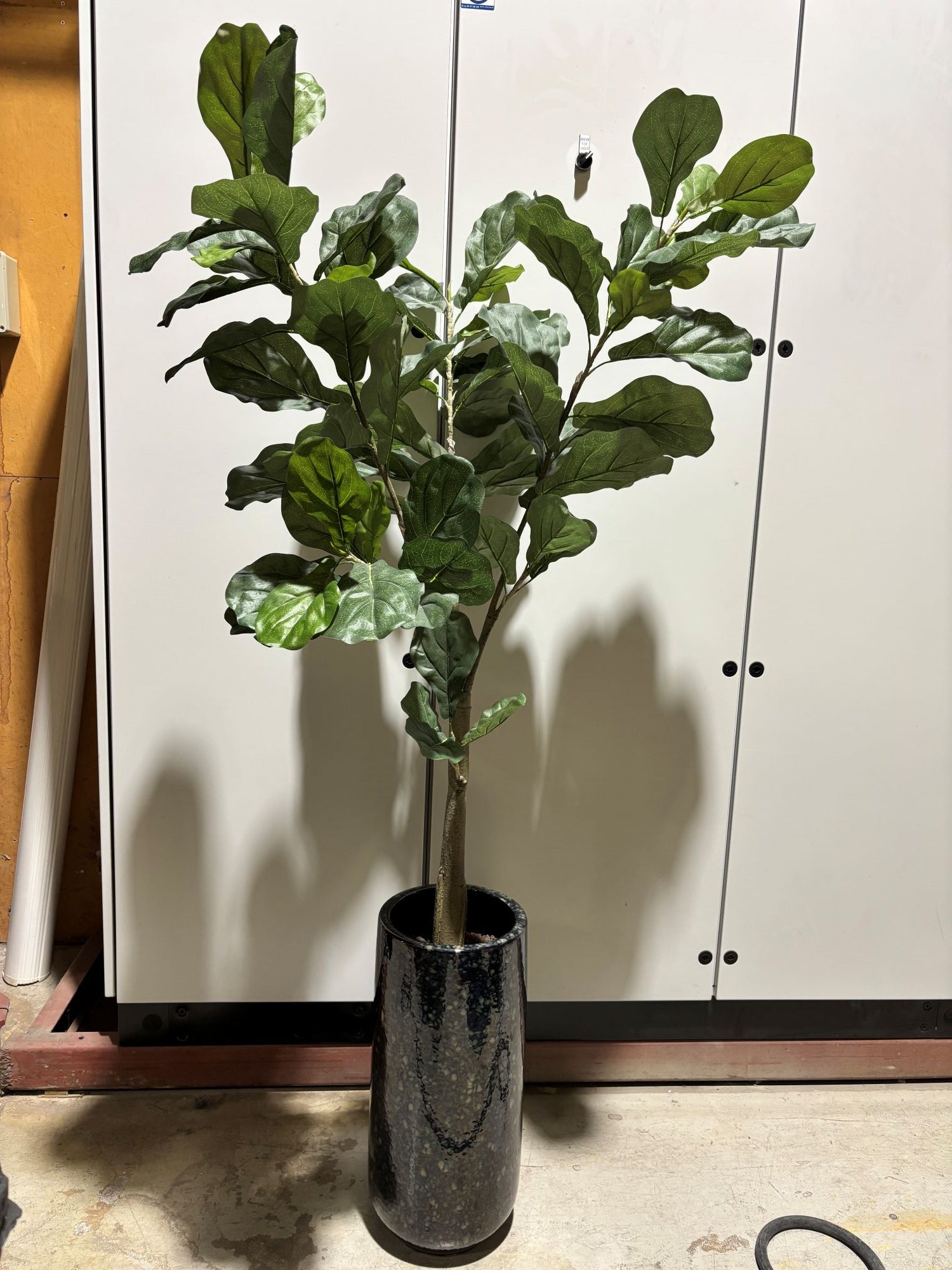 Kunstig grønn plante i keramikk potte